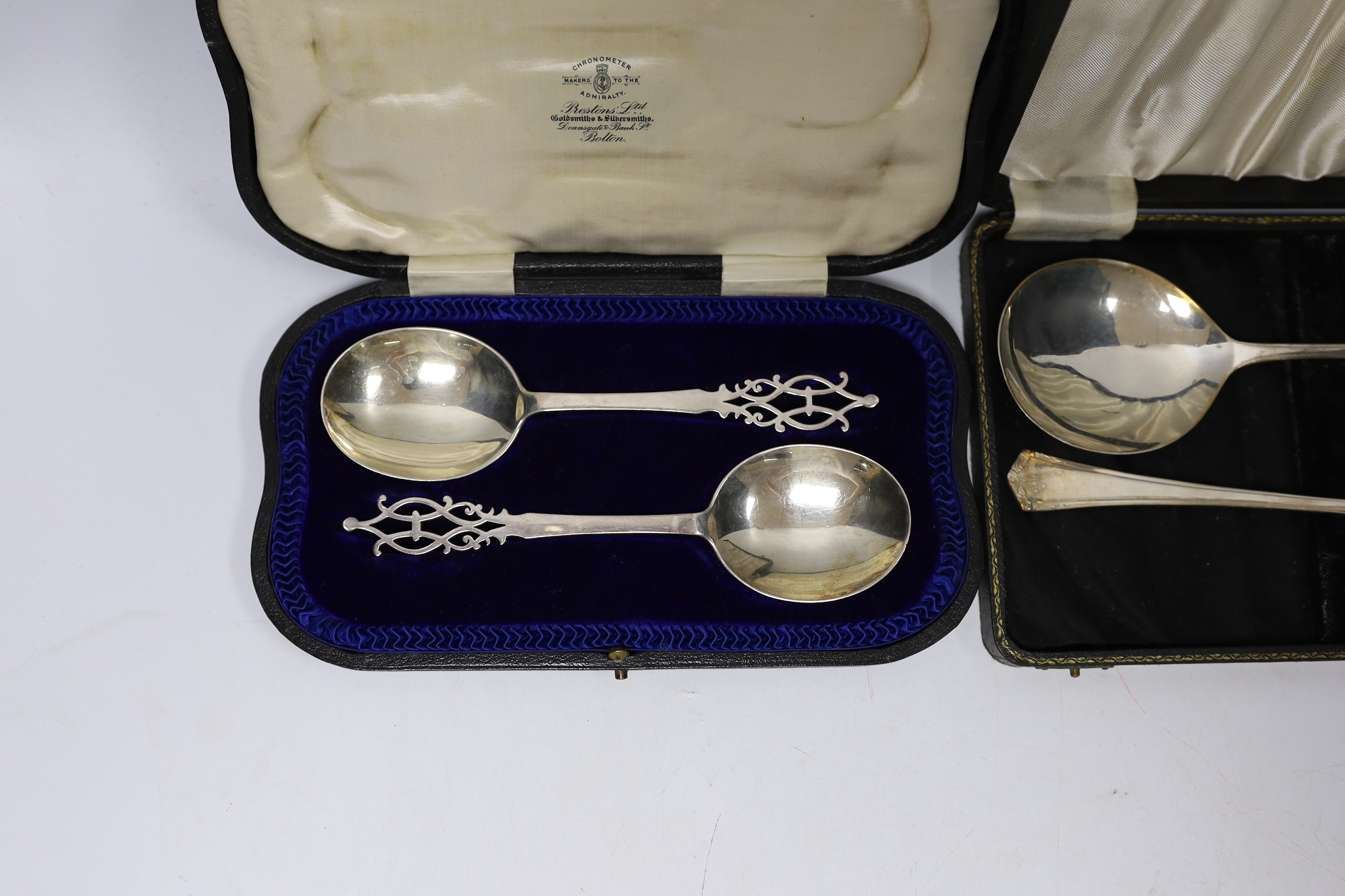 A cased pair of Edwardian silver serving spoons with pierced terminals, Josiah Williams & Co, London, 1907, 17.9cm and one other cased pair of silver servers.